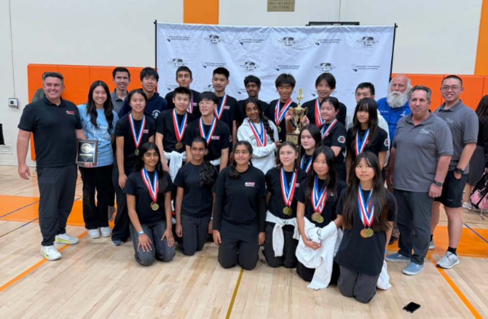 Sierra Vista team and coaches pose for a photo, holding a trophy and a plaque, all wearing medals.