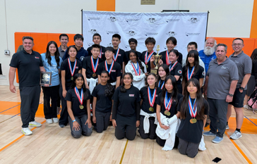 Sierra Vista team and coaches pose for a photo, holding a trophy and a plaque, all wearing medals.