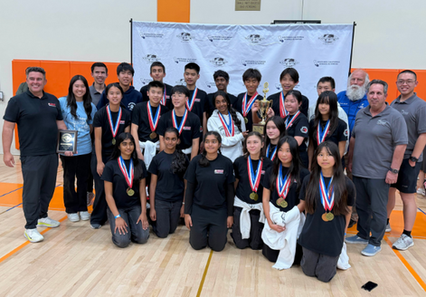 Sierra Vista team and coaches pose for a photo, holding a trophy and a plaque, all wearing medals.